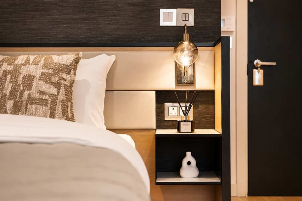 The open-plan living area features a comfortable double bed with quality bedding, creating a warm and inviting space to rest. Ideal for unwinding after a day spent discovering Manchester or working in the city.