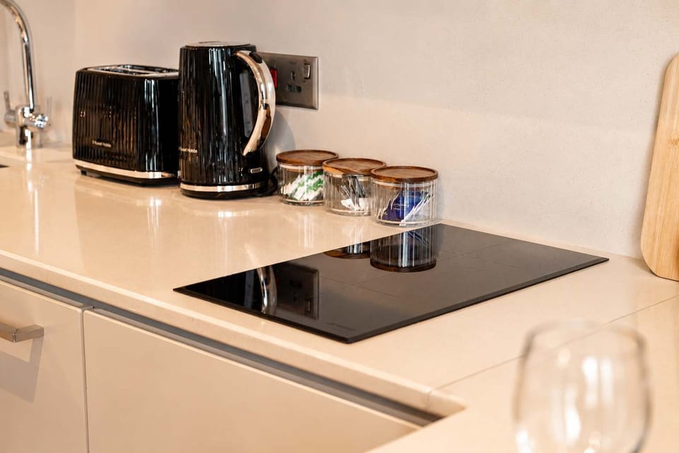 Enjoy the convenience of a modern kitchen with sleek finishes and essential appliances, including an oven, hob, and fridge/freezer. Cookware, crockery, and utensils are also provided for preparing meals with ease during your stay.