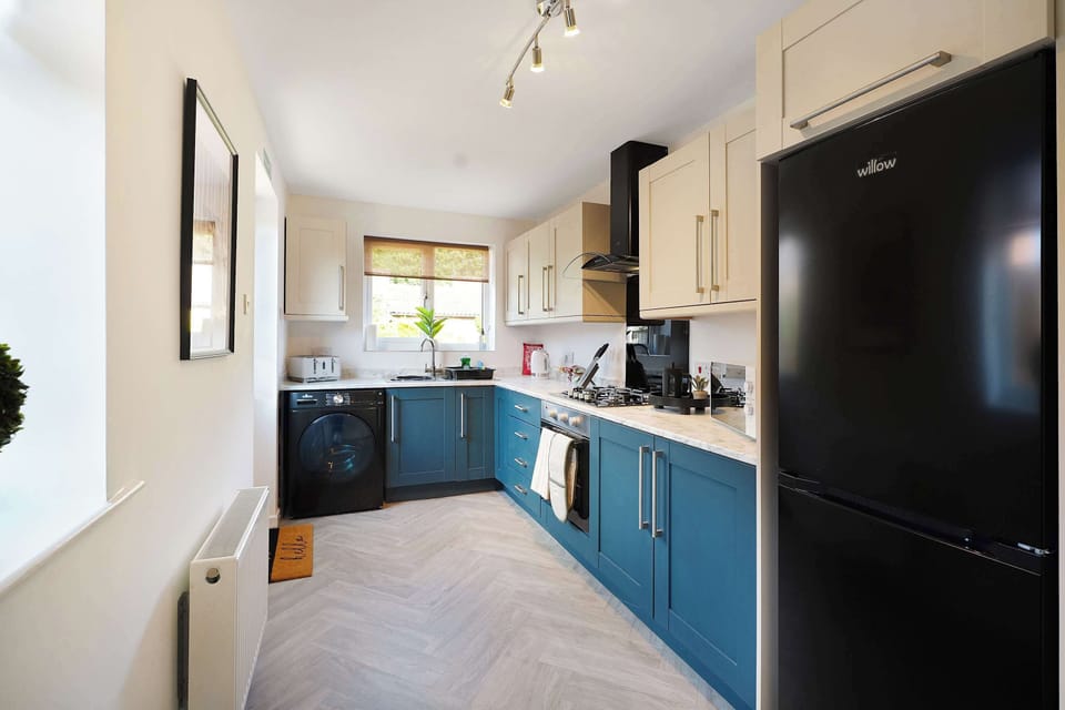 Thoughtfully designed kitchen complete with essential appliances, cooking facilities, ample storage and a washing machine, offering a practical space for cooking and laundry needs.