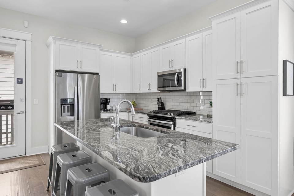 A genuinely well-stocked kitchen: gas range, stainless appliances, and a granite island with room to spread out. Whatever you cook for eight, the pans are already here.
