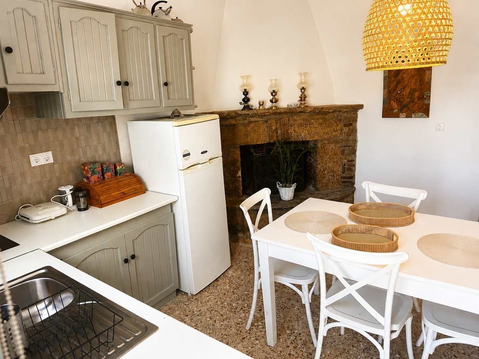 Fully Equipped Kitchen with Cooking Facilities, Storage Cabinets and Adjacent Dining Area