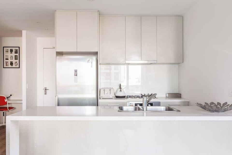 Prepare meals in the modern kitchen, equipped with a gas stove, oven, full-size fridge, and all the essentials for home-style cooking or simple snacks.