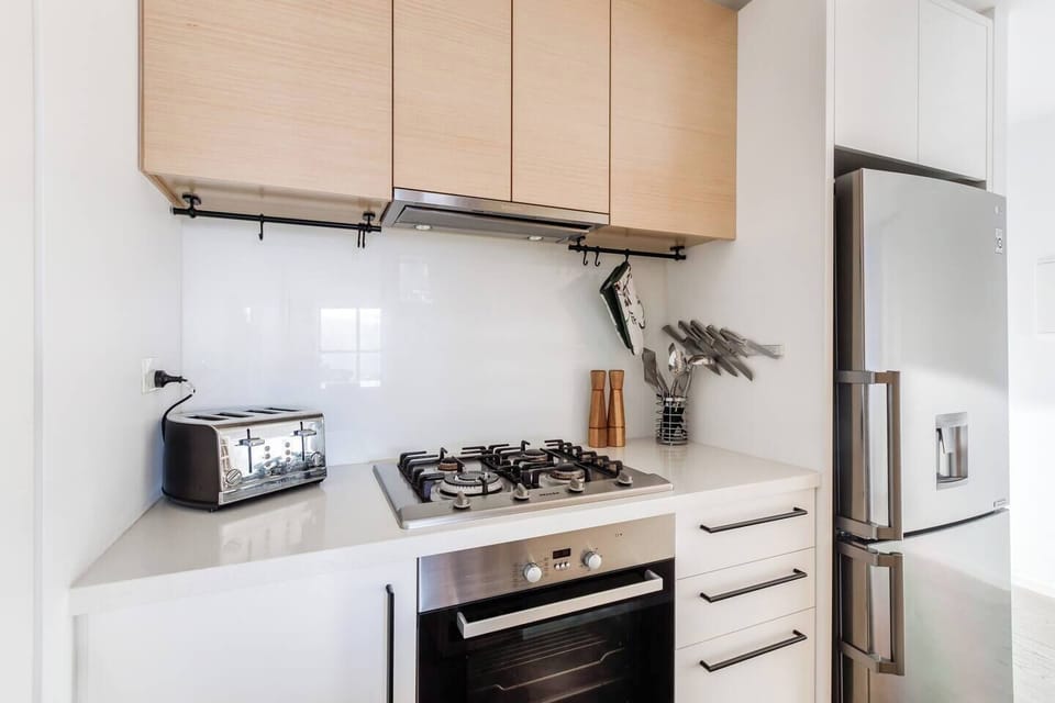 Prepare hearty meals in the sleek kitchen, featuring a full-size fridge, gas stove, oven, microwave, and other essentials for home-style meals.