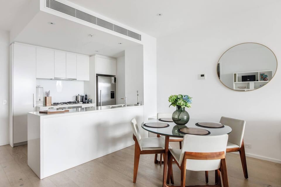 Savour slow breakfasts or evening wine at the dining table, with city lights glowing beyond and the seamless comfort of central air conditioning and heating setting the perfect mood.