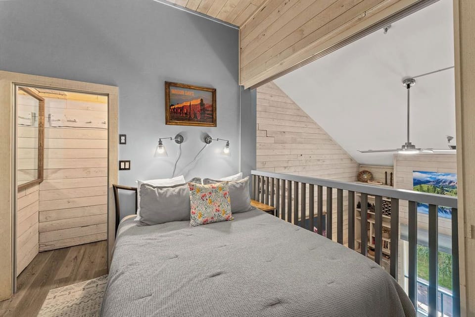 Cozy loft bedroom with vaulted wood ceilings and open cabin charm