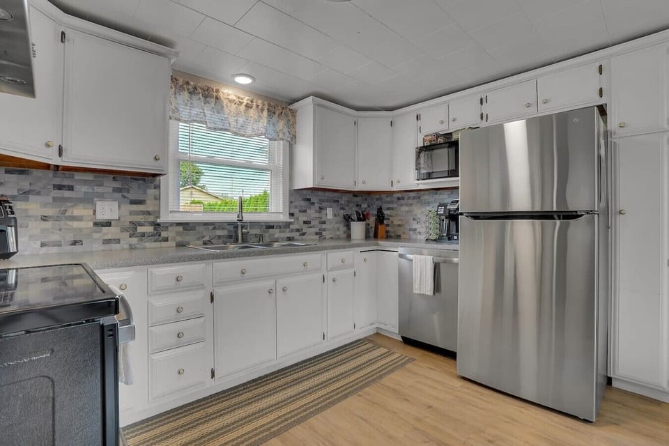 A clean and inviting kitchen with ample natural light, designed for both convenience and comfort while cooking.