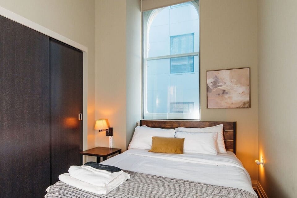 The master bedroom features an en-suite bathroom, original arched window, and an adjustable standing desk