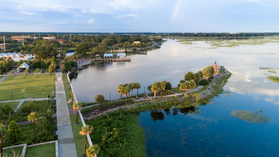 Scenic waterfront park with walking paths and a lighthouse.