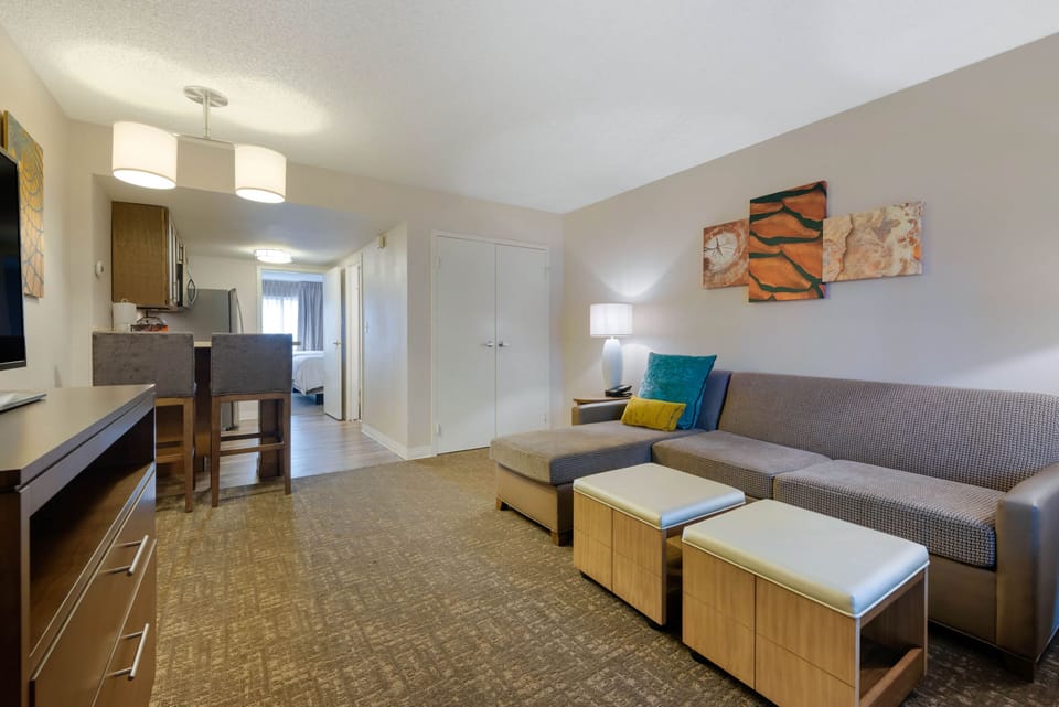 Living area with couch, artwork, and lamp.