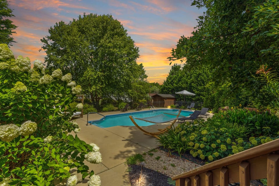 Private pool oasis with hammock, loungers, and lush sunset garden views
