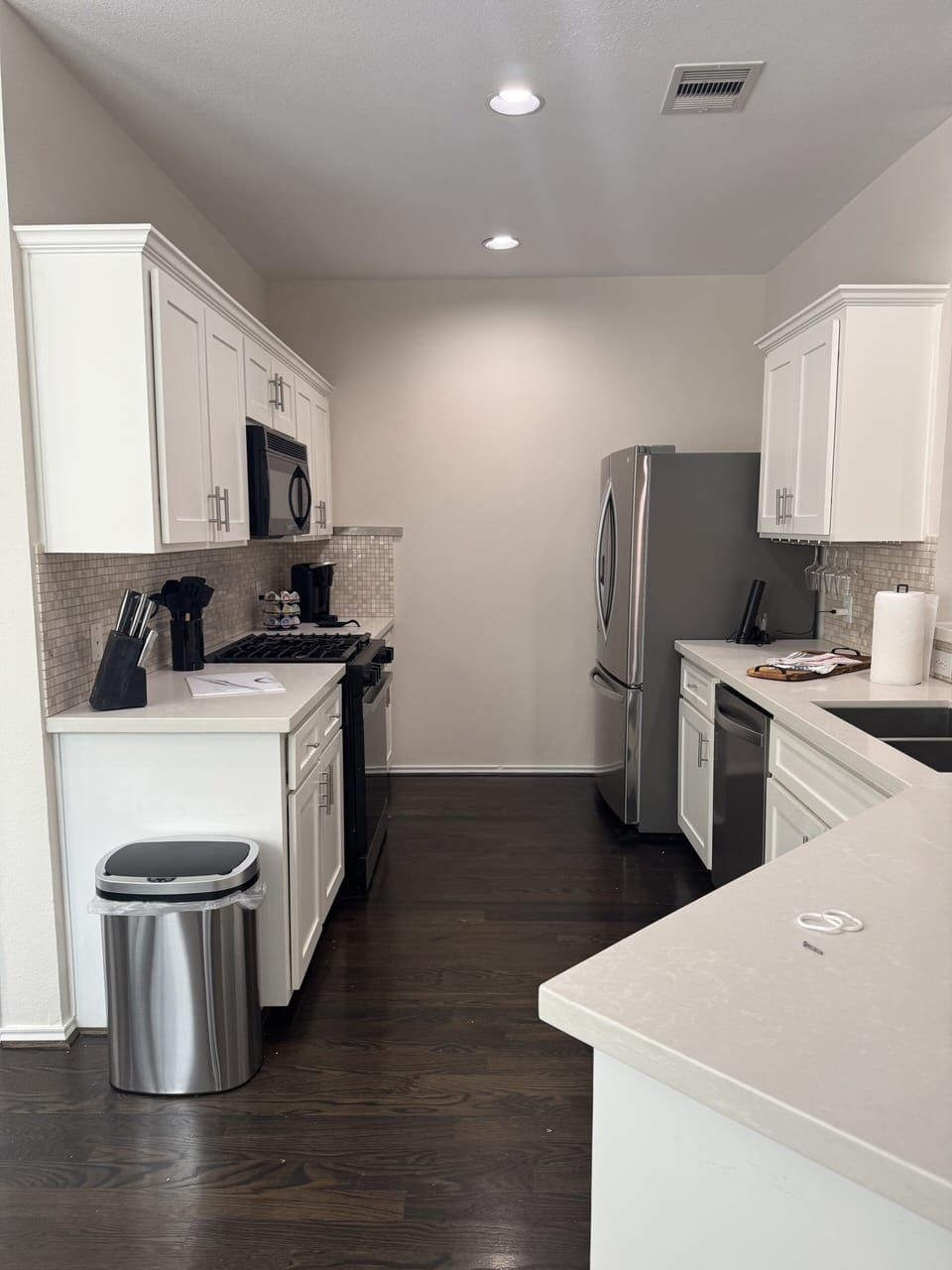 Modern galley kitchen with stainless appliances and breakfast bar
