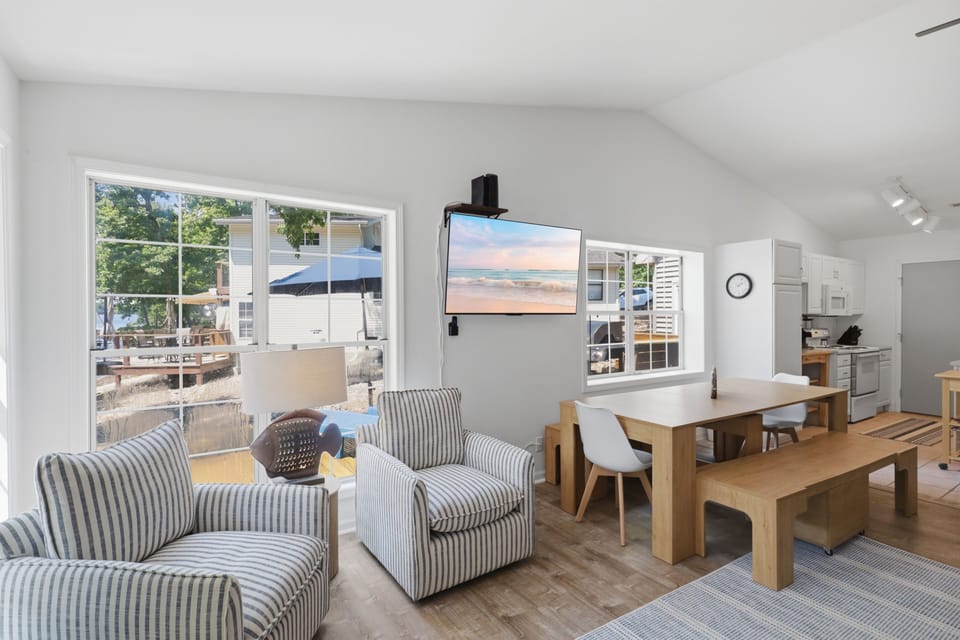 Open living area with large windows, dining space, and modern kitchen