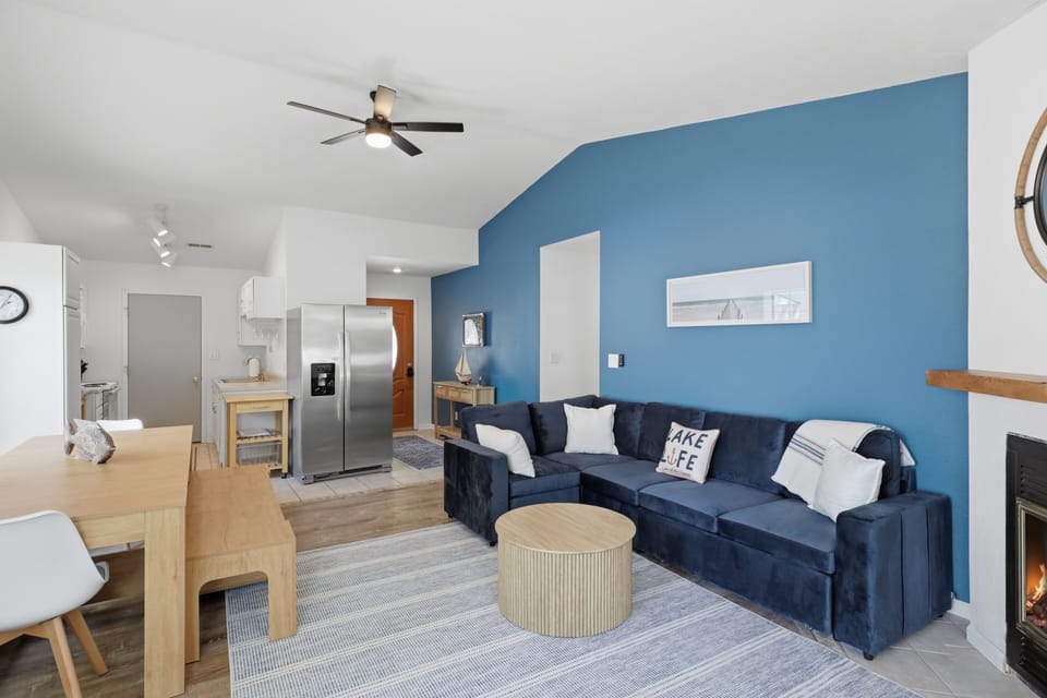 Open living space with bold accent wall, fireplace, and cozy sectional