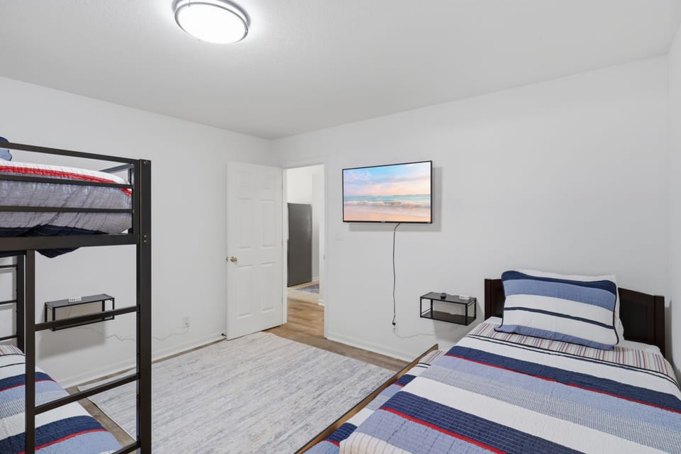Bunk room with twin beds and wall-mounted TV for group stays