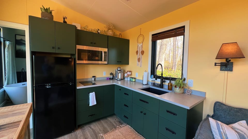 Stylish green kitchen with forest views, plus a spa-like bath steps away.