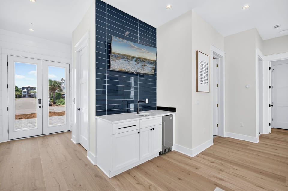 Ground-Floor Wet Bar & Refreshment Station – Features sink, beverage fridge, and ice maker near pool entrance