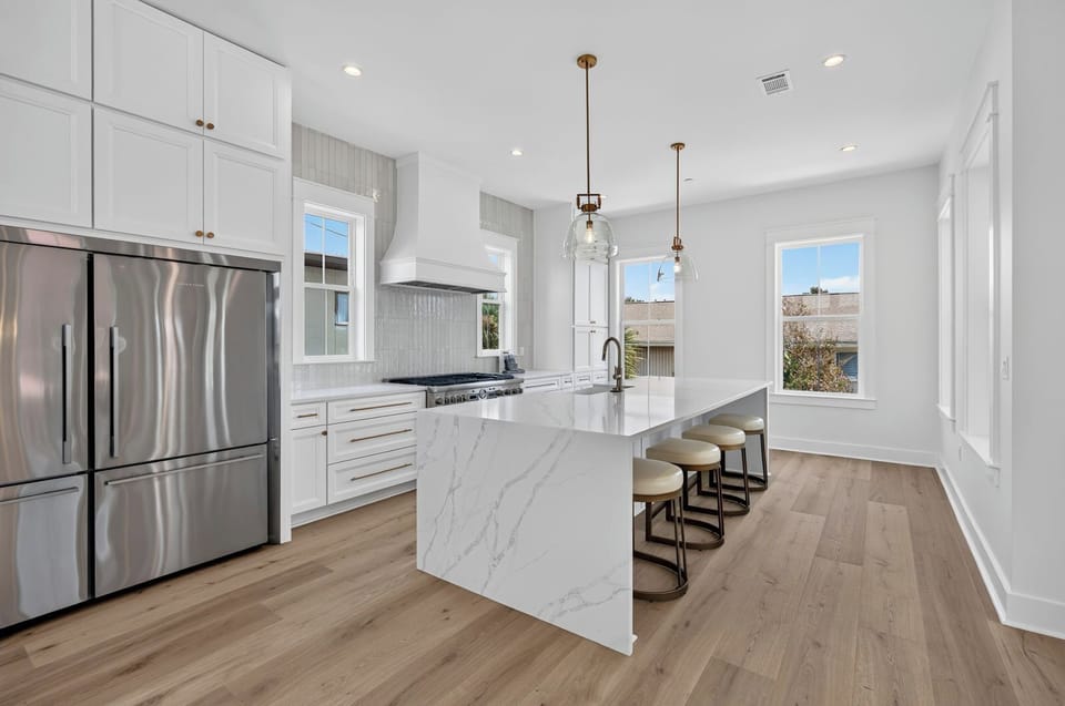 Gourmet Chef’s Kitchen – Premium Sub-Zero refrigeration, gas range, and waterfall island with seating for 4