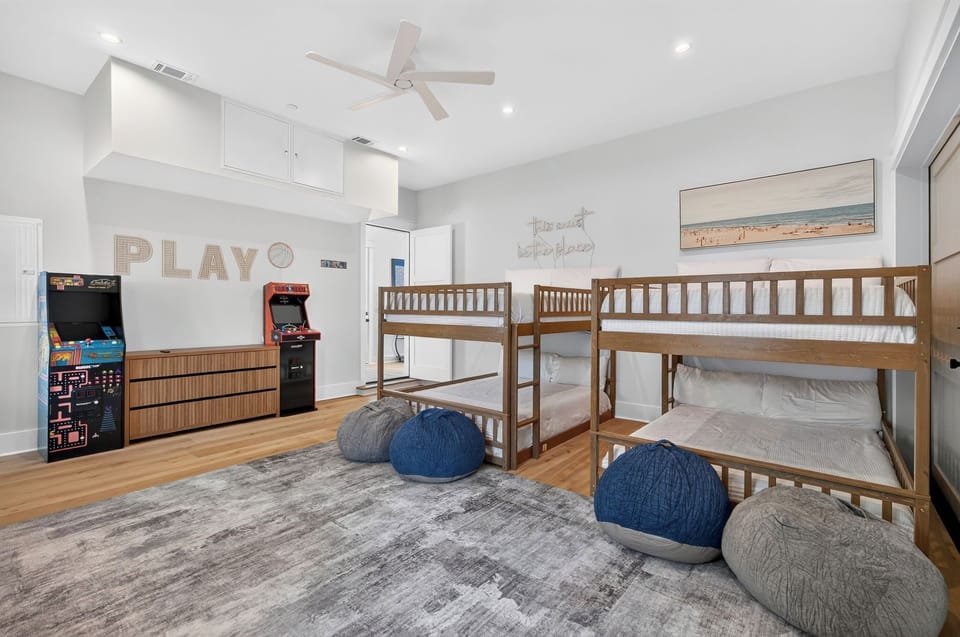 Bunk Room #1 Arcade Lounge – Features 2 queen-over-queen custom bunks (sleeps 8), bean bag seating, retro arcades, and full-length table shuffleboard
