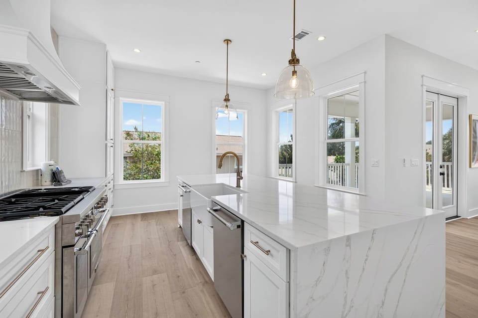 Chef’s Kitchen View – Professional 6-burner gas range, custom hood, and expansive counter space for large groups