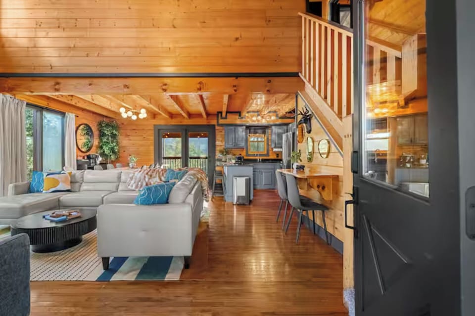 Step inside and be welcomed by soaring wood-beamed ceilings, warm cabin charm, and an open-concept layout designed for gathering. 