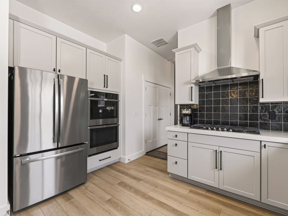 A modern, well-appointed culinary space featuring stainless steel appliances, ample counter space, and quality cabinetry. The open layout creates an inviting space for meal preparation while staying connected to the rest of the home. Clean lines and contemporary finishes make this kitchen both functional and stylish for entertaining.