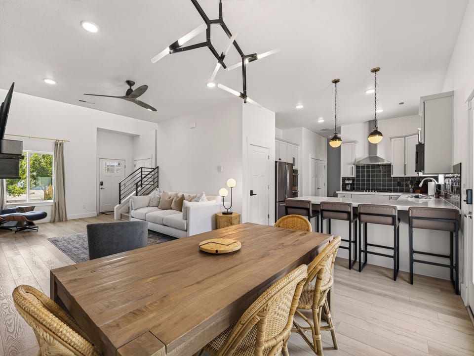 A bright and spacious gathering space with high ceilings and abundant natural light. Modern furnishings and contemporary design create a welcoming atmosphere perfect for entertaining or relaxing as a family. The open floor plan seamlessly connects to dining and kitchen areas, making this the heart of the home ideal for both daily living and hosting guests.