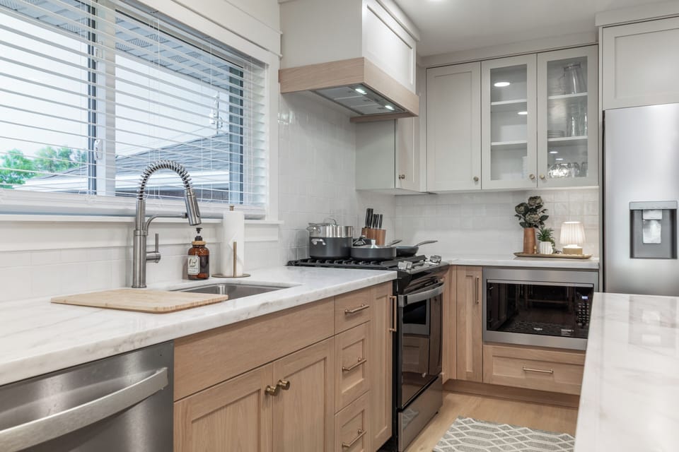 Bright modern kitchen with marble counters and stainless appliances