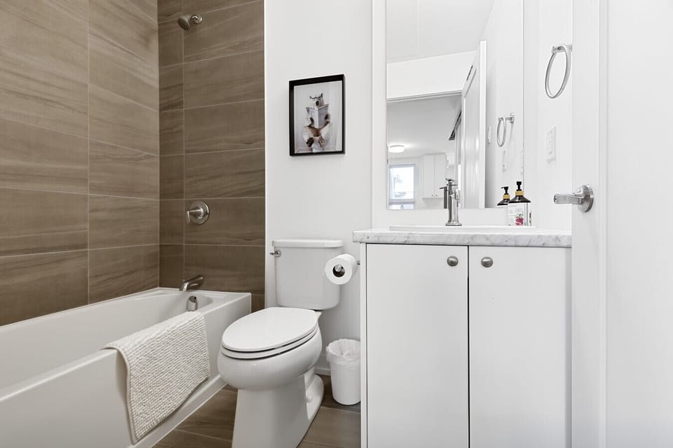 Refresh in a sleek, spa-inspired bathroom designed with clean contemporary finishes. Featuring a full bathtub and shower combination, bright vanity, fresh towels, and complimentary essentials, this space offers everything you need to start or end your day