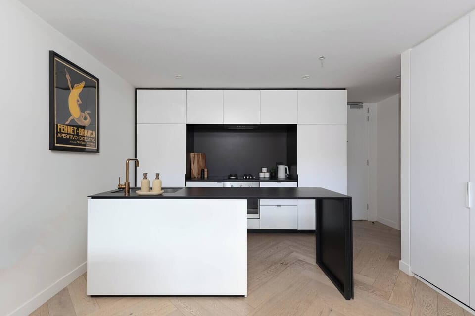Prepare meals or pour a morning coffee at the sleek kitchen bench, a perfect spot for casual dining or entertaining.