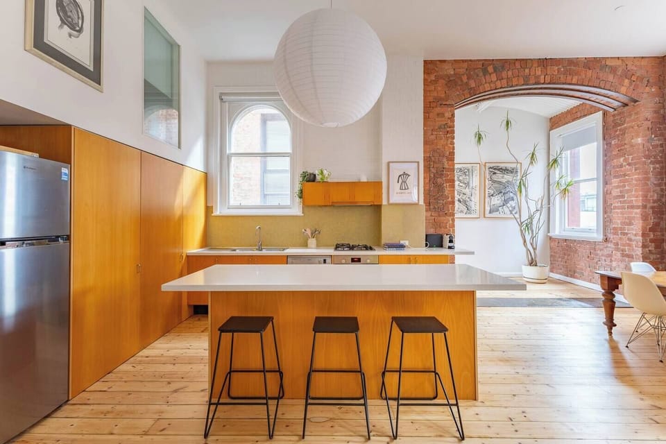 Fully equipped with a gas cooktop, oven, microwave, dishwasher, toaster, kettle, French press, and fridge-freezer, the kitchen combines practicality with clean, minimalist design for effortless home cooking.