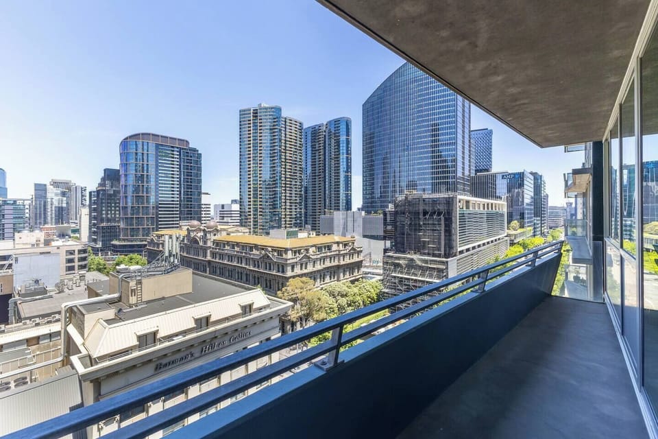 Watch the city shift from day to night as lights flicker across surrounding buildings and leafy streets below.