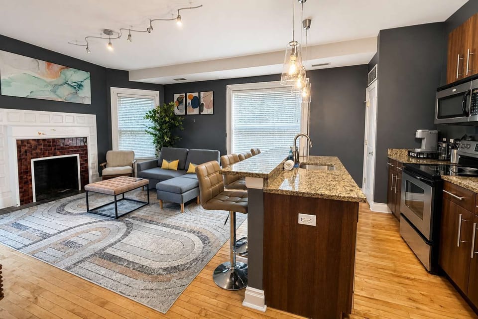 Open living + kitchen — granite island, fireplace, and room to settle in for weeks