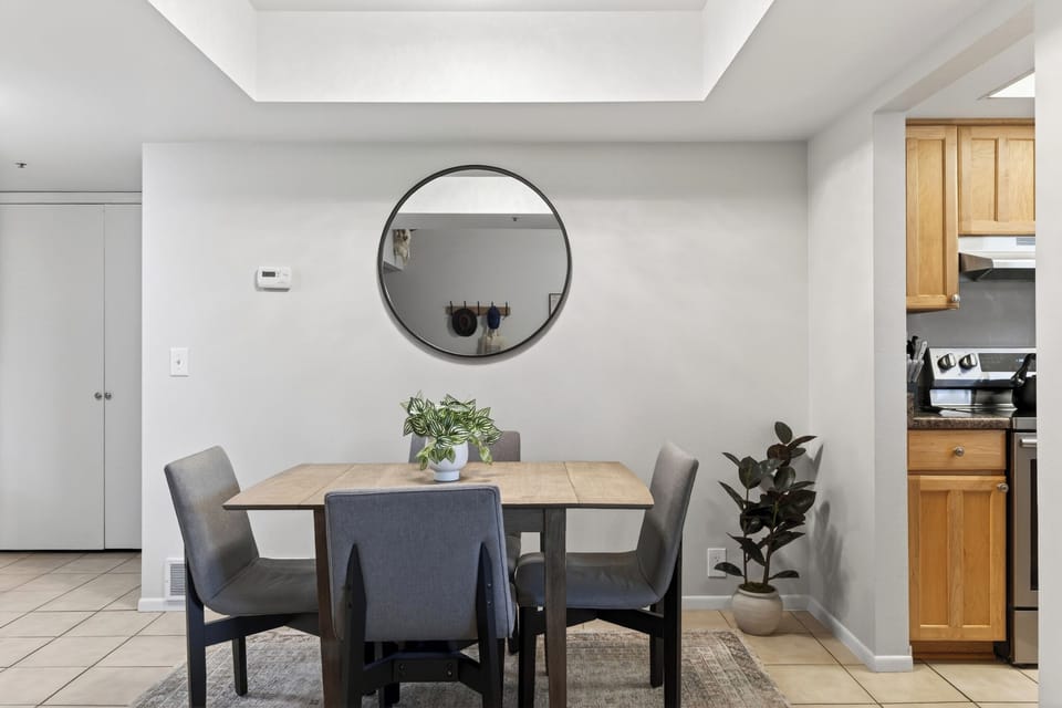 Dining area set against a white wall with a large decorative mirror.