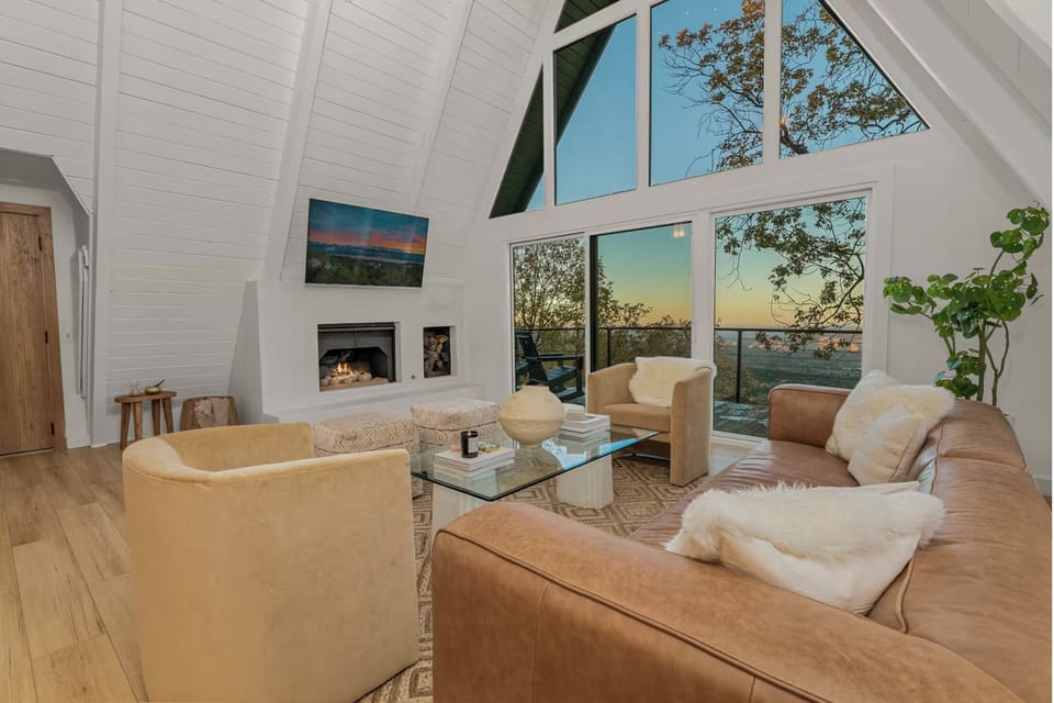 Vaulted living room with floor-to-ceiling windows and plush seating.