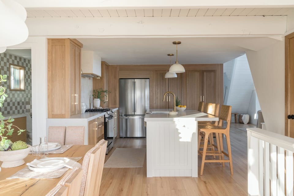 Bright open kitchen featuring light wood cabinetry and stainless steel appliances.
