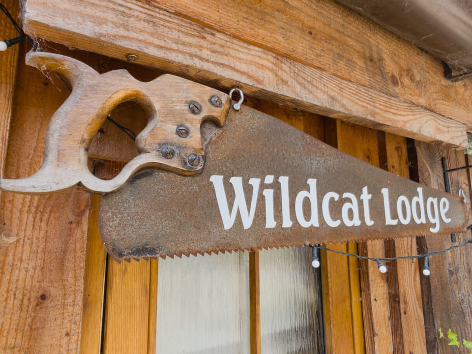 An old saw blade, hand-painted and hung under the eaves with a string of lights beneath it. You'll know you're in the right place.