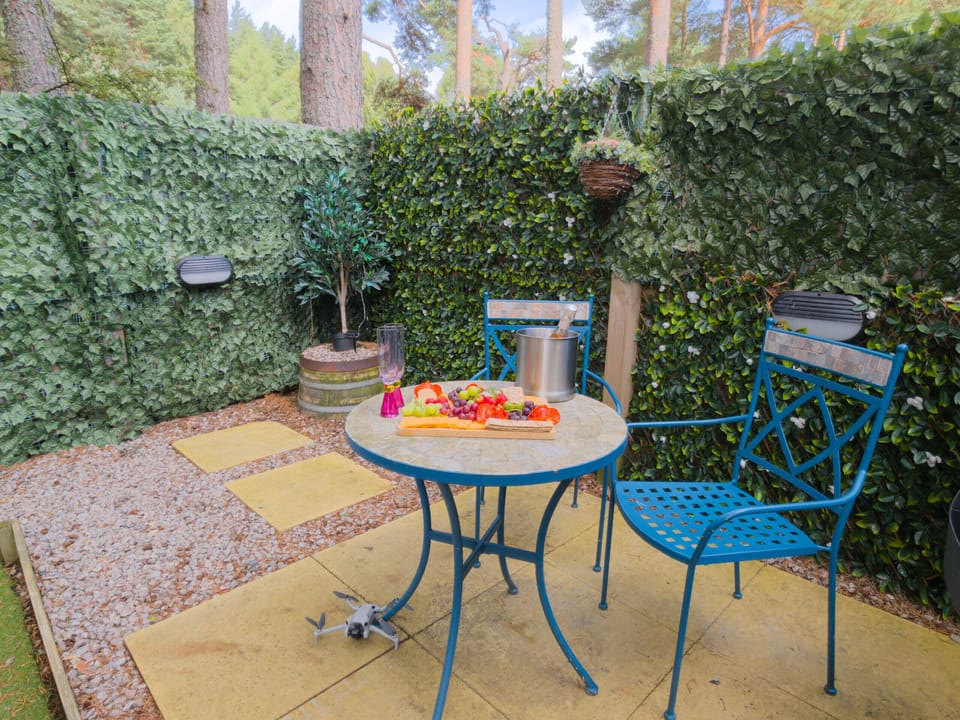 A paved corner sheltered by greenery, with just enough room for a table, two chairs and a long lunch outside.