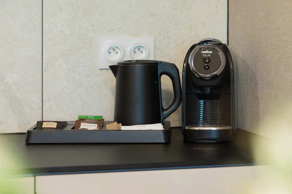 Close-up of kitchen countertop with coffee machine, electric kettle and other small appliances.