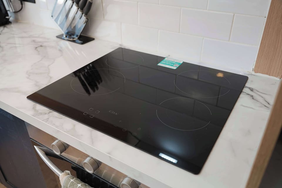The kitchen is thoughtfully equipped with an oven, hob, microwave, fridge/freezer, washing machine, breakfast table, and all the cookware needed to prepare breakfasts, lunches, and evening meals.