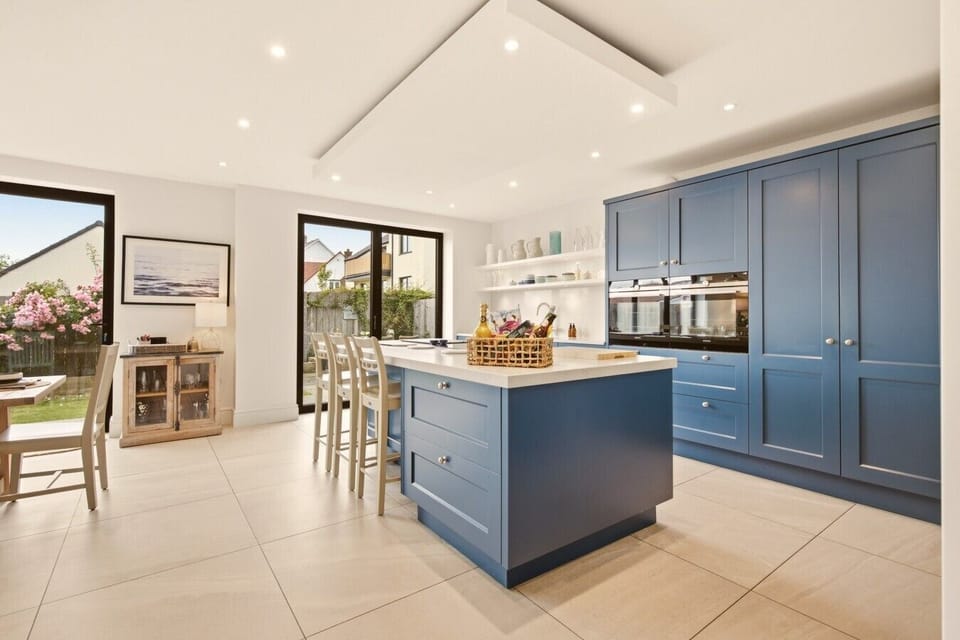 Contemporary kitchen with blue cabinetry, island seating and garden access