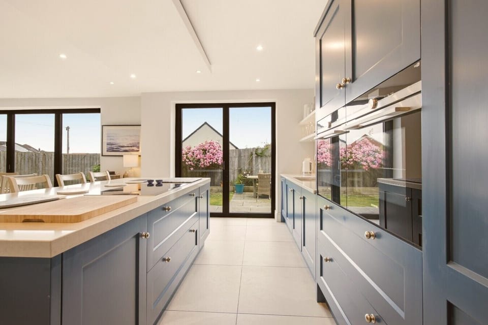 Galley-style kitchen with quartz worktops, integrated appliances and island