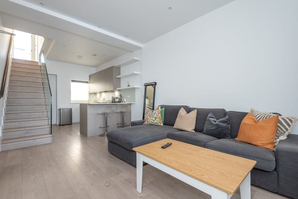 Spacious open-plan living area combining lounge, kitchen and staircase