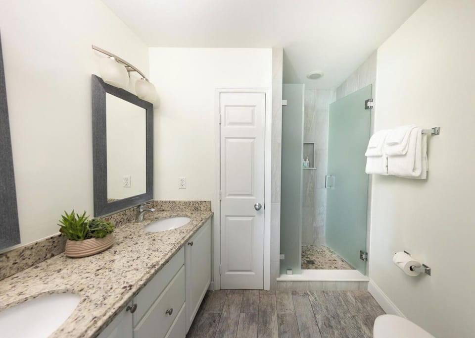 Refresh in the sleek bathroom with glass walk-in shower.