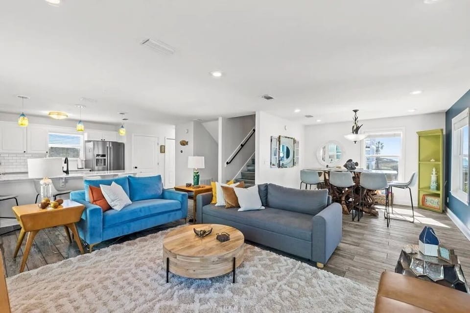 Unwind in your open-plan living space, where vibrant pops of color, cozy seating, and modern design create the perfect gathering spot after a day of exploring.