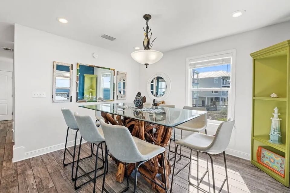Gather around this stunning driftwood dining table where your group can share meals and make memories together. Natural light pours through multiple windows as you enjoy the coastal-inspired décor.