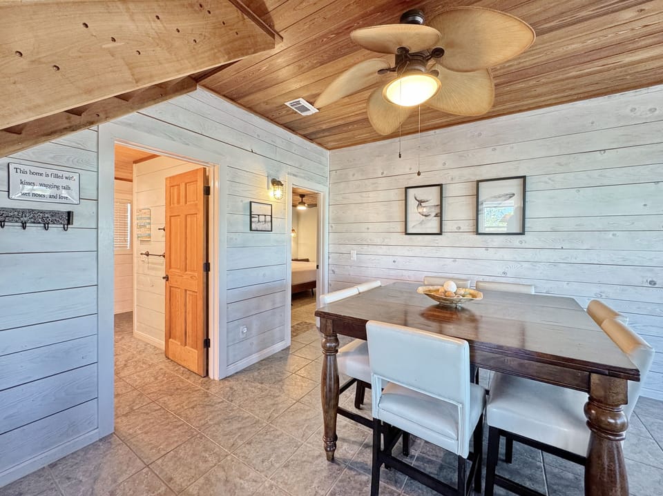 Gather around your rustic dining table beneath exposed wooden beams and a gentle ceiling fan for memorable meals together.