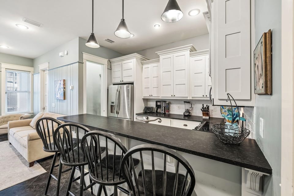 Gather around the sleek breakfast bar in this bright, welcoming kitchen, where modern appliances and thoughtful design make cooking feel effortless. Enjoy morning coffee or casual meals in this elegant, open space.