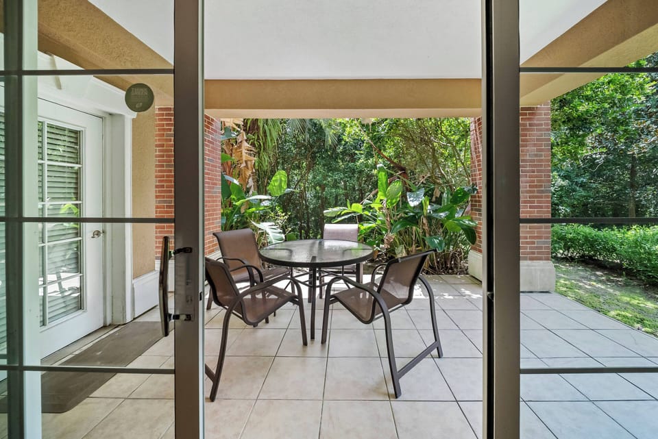 Step outside to your private patio, where a glass table surrounded by sleek, weather-resistant chairs invites you to enjoy al fresco dining. Lush greenery enhances the tranquil ambiance, creating a perfect spot for relaxation.