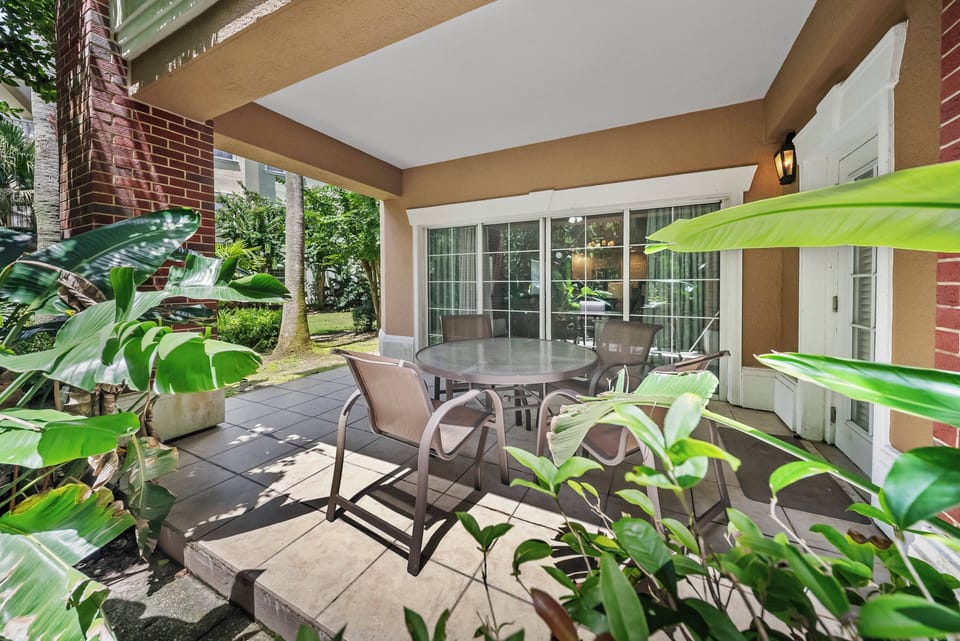 Discover your outdoor oasis with a spacious patio featuring stylish wicker furniture and lush greenery, ideal for alfresco dining or enjoying a peaceful morning coffee in the warm natural light.