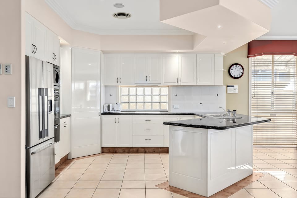Prepare everything from beach-day snacks to dinner at home in the sleek kitchen, with generous cabinetry, broad benchtops and a full suite of everyday appliances close at hand.